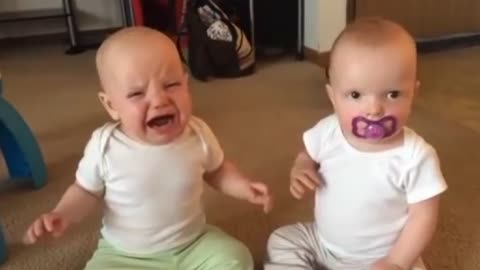 Twin baby girls fight over pacifier