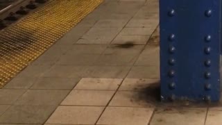 Man bent down on edge of train station