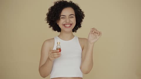 A Woman Laughing With A Bottle Of Essential Oil On Hand