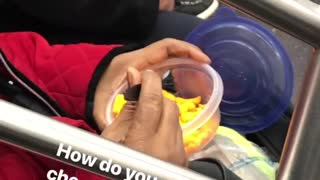 Woman eats cheetos with fork on subway train