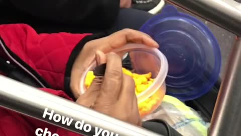 Woman eats cheetos with fork on subway train