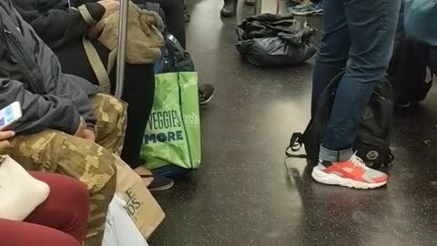 Man in red shirt claps and walks thru subway