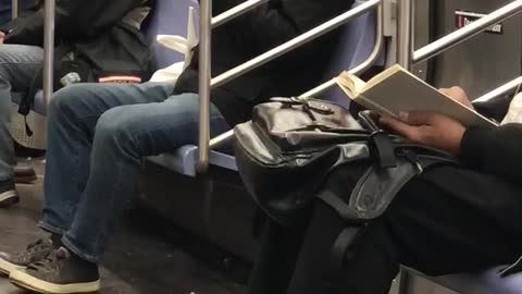 Man bites off apple skin and spits it out onto napkin on subway