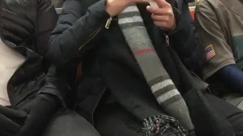 Lady in black jacket filing her nails on train