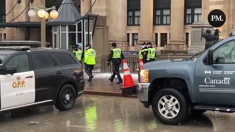 A fence appears to be being built as large numbers of police move through the area where the freedom protest in Ottawa continues