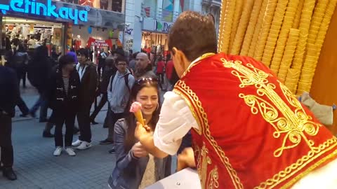 Cute girl and Turkish Ice Cream Master in Istanbul Making Fun