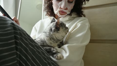 A Woman Holding Her Cat while Using Smartphone