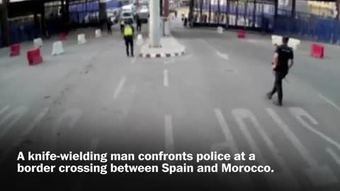 Spanish police throw traffic barrier at knife-wielding man