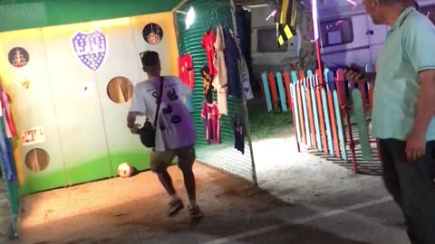 Guy Kicking Soccer Ball at Carnival Game Misses the Mark