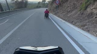 Motorcycle Follows Wheelchair Down Hill