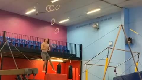 Guy Juggles Multiple Rings While Balancing Himself Over Slackline