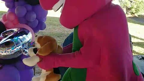 Purple dinosaur sings and dances to bingo at a birthday party at city ranch in Houston Texas