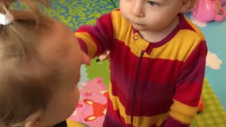 Twin babies learn to be gentle with each other