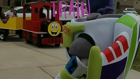 See this mascot party characters Buzz the astronaut toy stand against the train.
