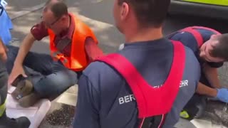 German Eco-activist screams as emergency service workers try remove his glued hand from the road.