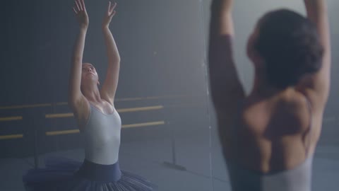 A ballet dancer practicing in front of a mirror