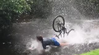 Slow motion guy riding bike into lake