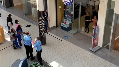 Man Casually Strolls Past Woman Pointing Gun Inside Mall