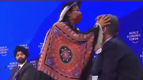Bizarre WEF Display: From Strict Covid Regulations To Having A Native Woman Coughing In Their Faces