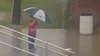 Boy Dances In The Rain Using His Umbrella As A Prop