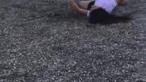 Epic fail girl on green playground ride falls off onto wood chips floor