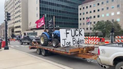 A truck with a ‘F*** Joe Biden’ sign on a tractor pulls up in front of the Capitol