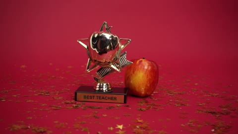 A Best Teacher Award beside an Apple
