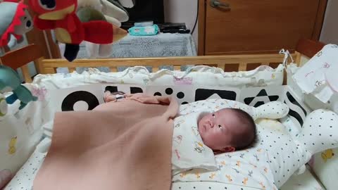 A baby yawning because he was bored than a strange mobile