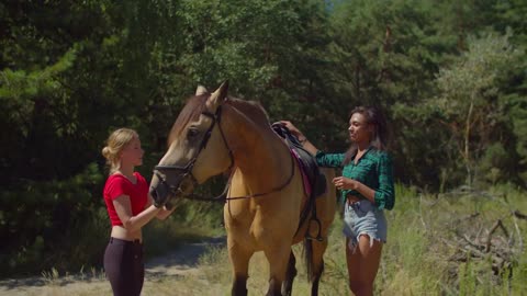 Positive attractive african woman rider getting off saddle after horseback