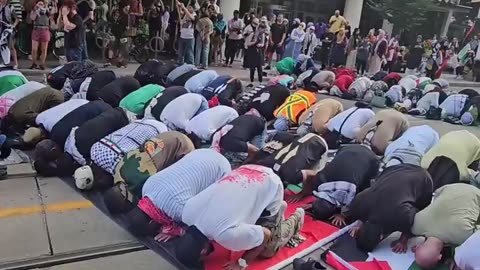 Muslims block the tram rail to pray while hundreds of Canadian passengers wait for them.