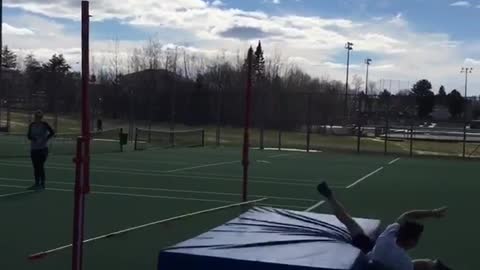White shirt does high jump goes too far and misses mat