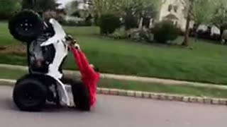 Guy red sweater jacket tries to do wheelie on atv falls on butt