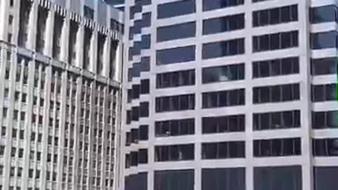 Long distance office building guy dabbing in window