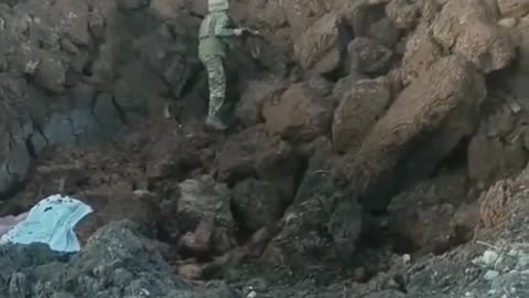 An AFU soldier climbed into a huge crater left after a strike of a Russian aerial bomb