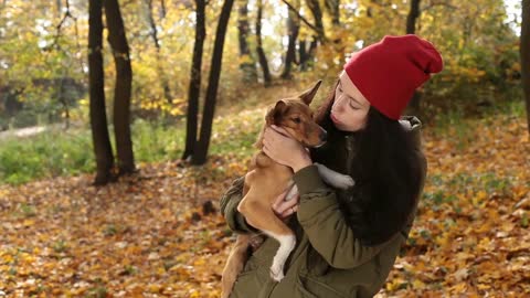 Tender scene of woman with dog in autumn park