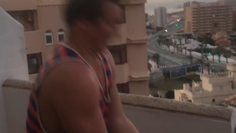 Guy in striped tank top opens beer can with head