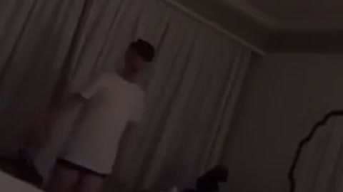 Drunk guy in white shirt stumbles in hotel room