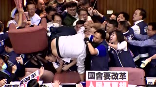 Taiwanese lawmaker climbs over crowd amid chaos