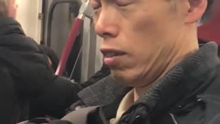 Man on subway closes his eyes and raises his eyebrows up and down