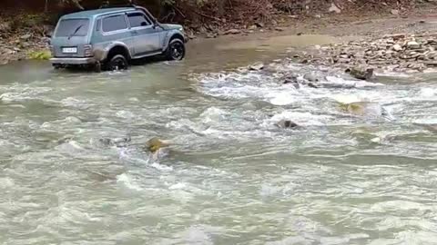 Автомобиль переежает через горную реку/The car runs across the mountain river