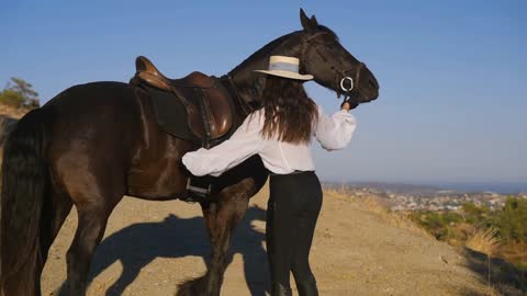 Female rider training horse in sunny summer mountains