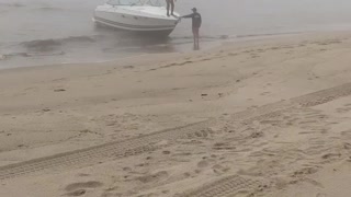 Man Trying to Land a Boat Parallel to the Beach