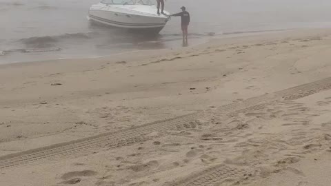 Man Trying to Land a Boat Parallel to the Beach