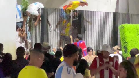 Soccer Fans Climb Over Fence at Stadium