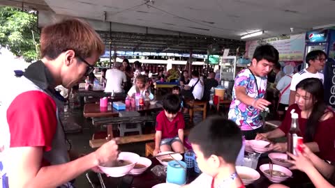 Flooded Thai noodle stall buzzing with customers