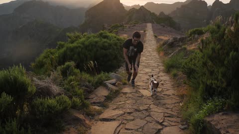 Man running with a dog on a mountain