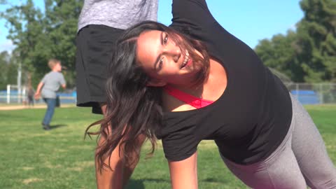 A Man Goofing Beside A Woman Exercising Over A Yoga Mat