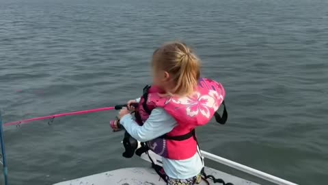 Girl Holds on Tight While Reeling in Fish