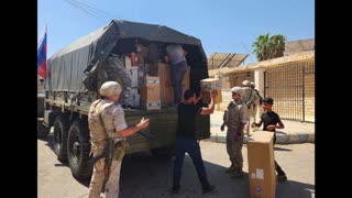 Russian servicemen deliver grocery kits to residents of Busra in Syrian Daraa province