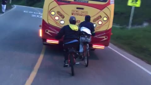 Kids on bikes hitch ride from back of bus